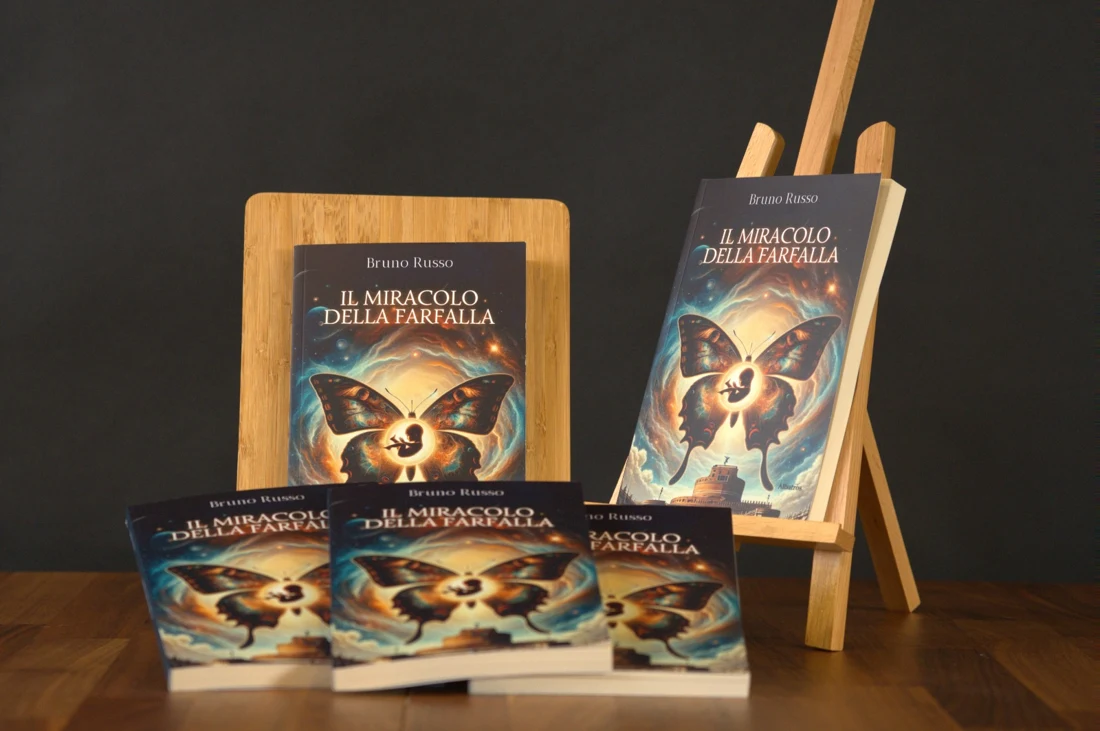 Copie del romanzo Il miracolo della farfalla esposte su un tavolo e un cavalletto
